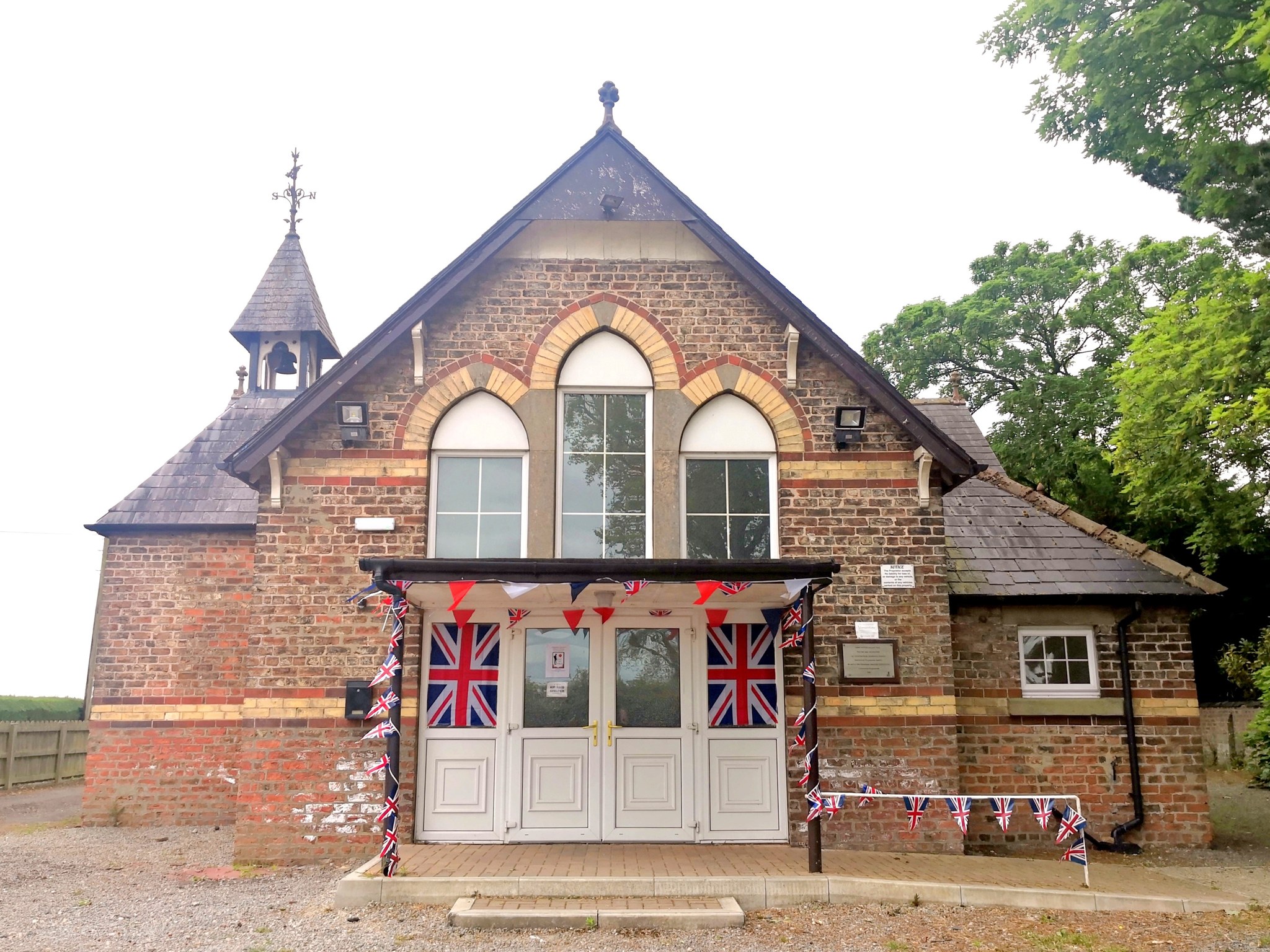 The outside of the Sandhutton Village Hall, decorated with union flags